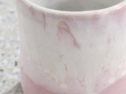 Close-up of soft pink and creamy white glaze on handmade ceramic mug