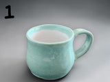 Handmade green ceramic cup with glossy glaze