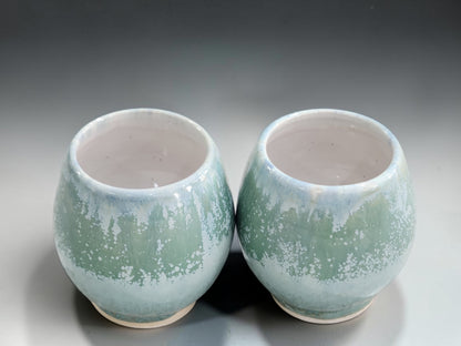 Small ceramic whisky cups with rounded shape and unglazed clay foot rings