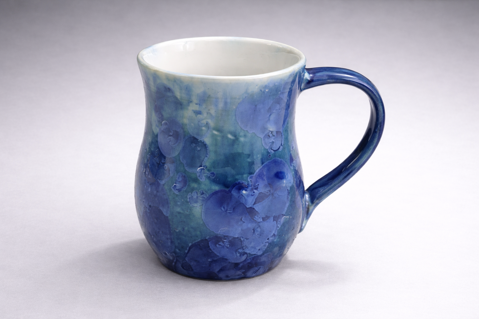 Front view of blue ceramic mug with layered aqua and cobalt glaze