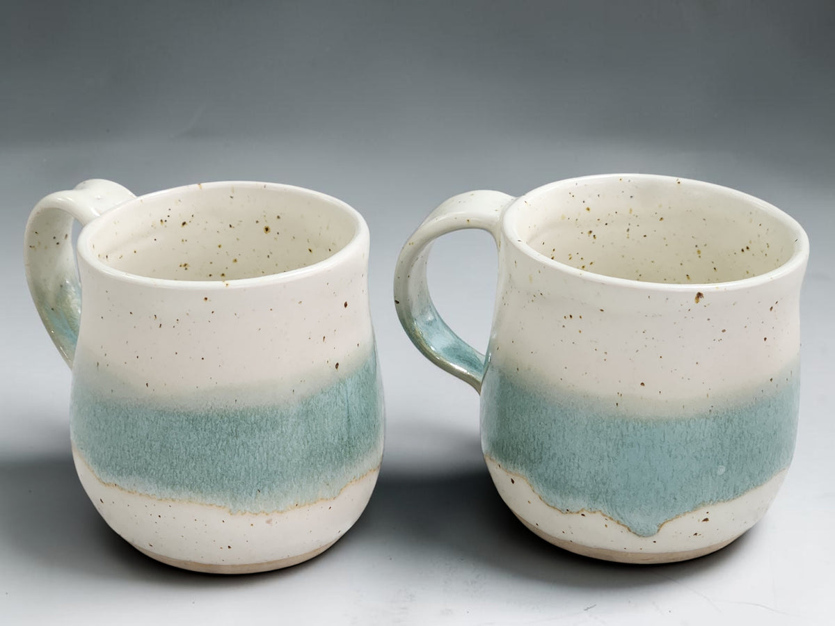 Handmade stoneware coffee mug with cream and green variegated glaze