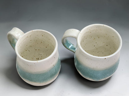 Food-safe handmade pottery mug with speckled cream and green glaze.