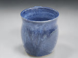 Handmade blue pottery mug in warm kitchen lifestyle setting