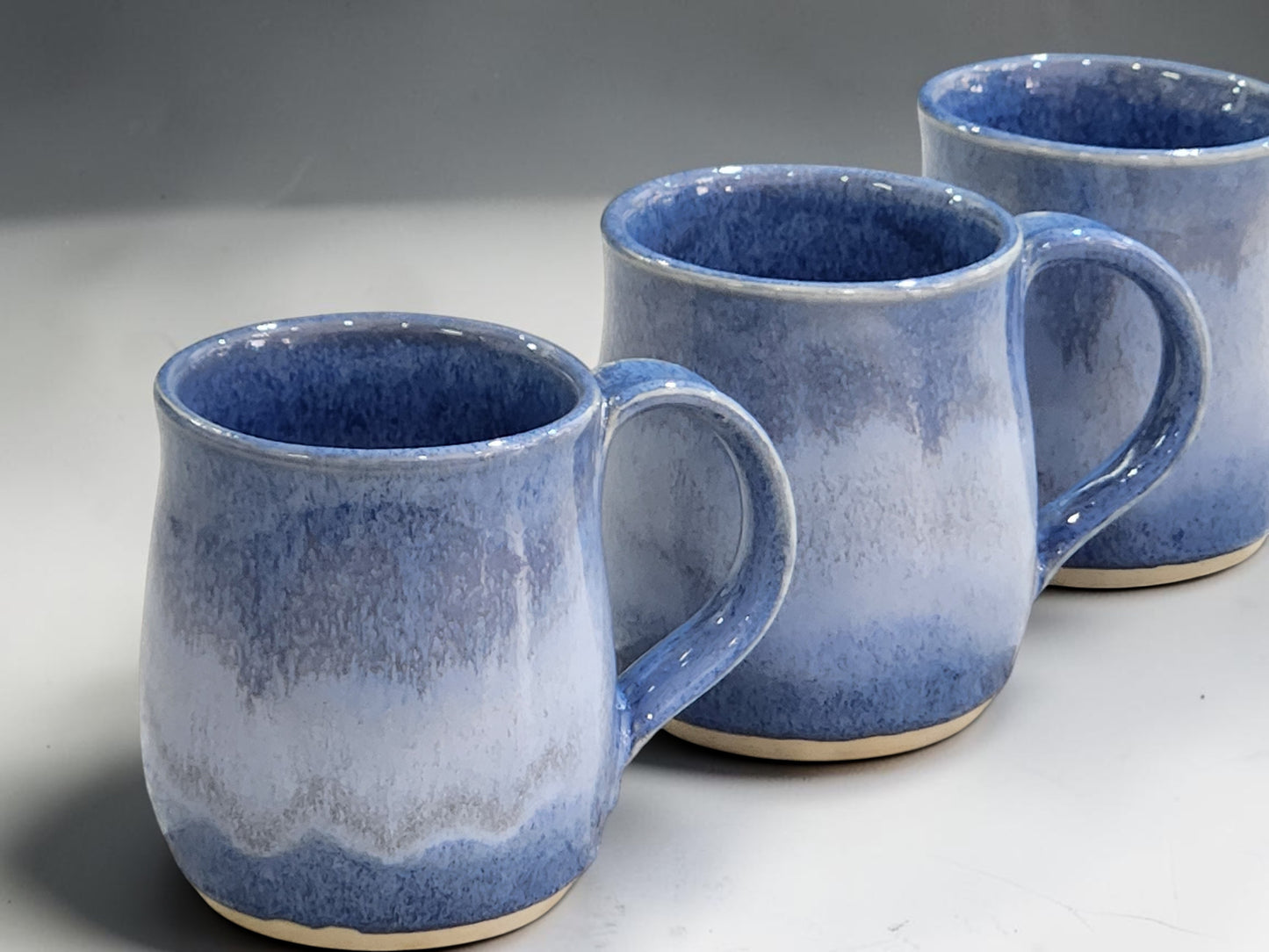 Handmade ceramic mug in soft blue glaze holding 300ml