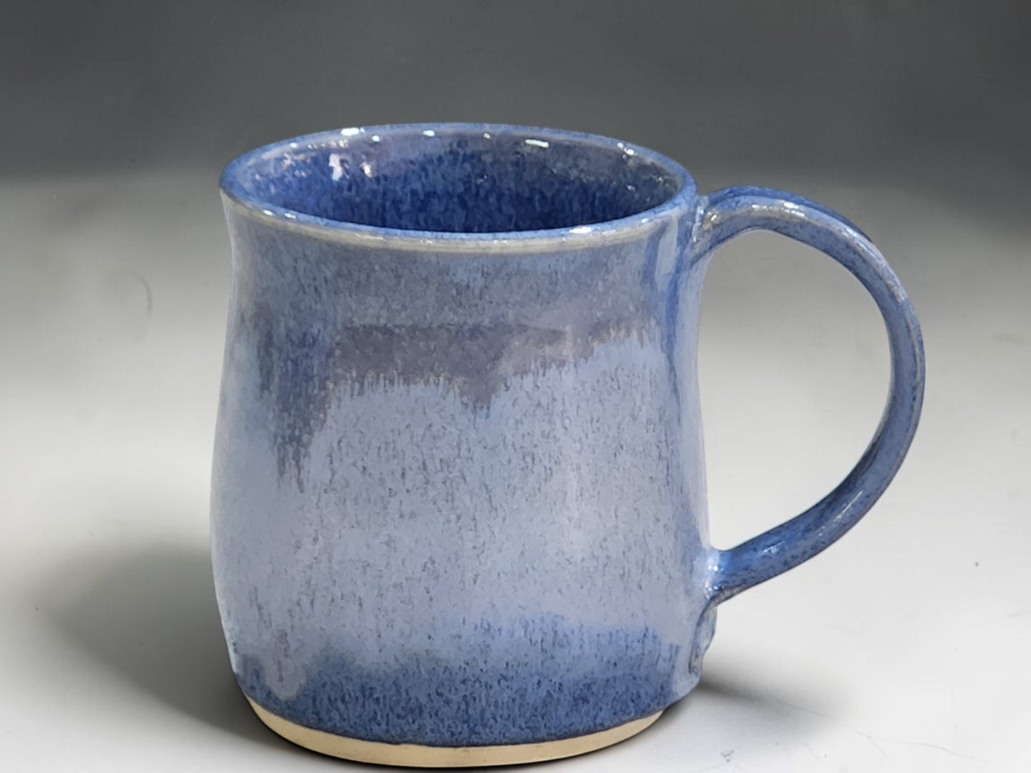 Handmade stoneware coffee mug with blue variegated glaze