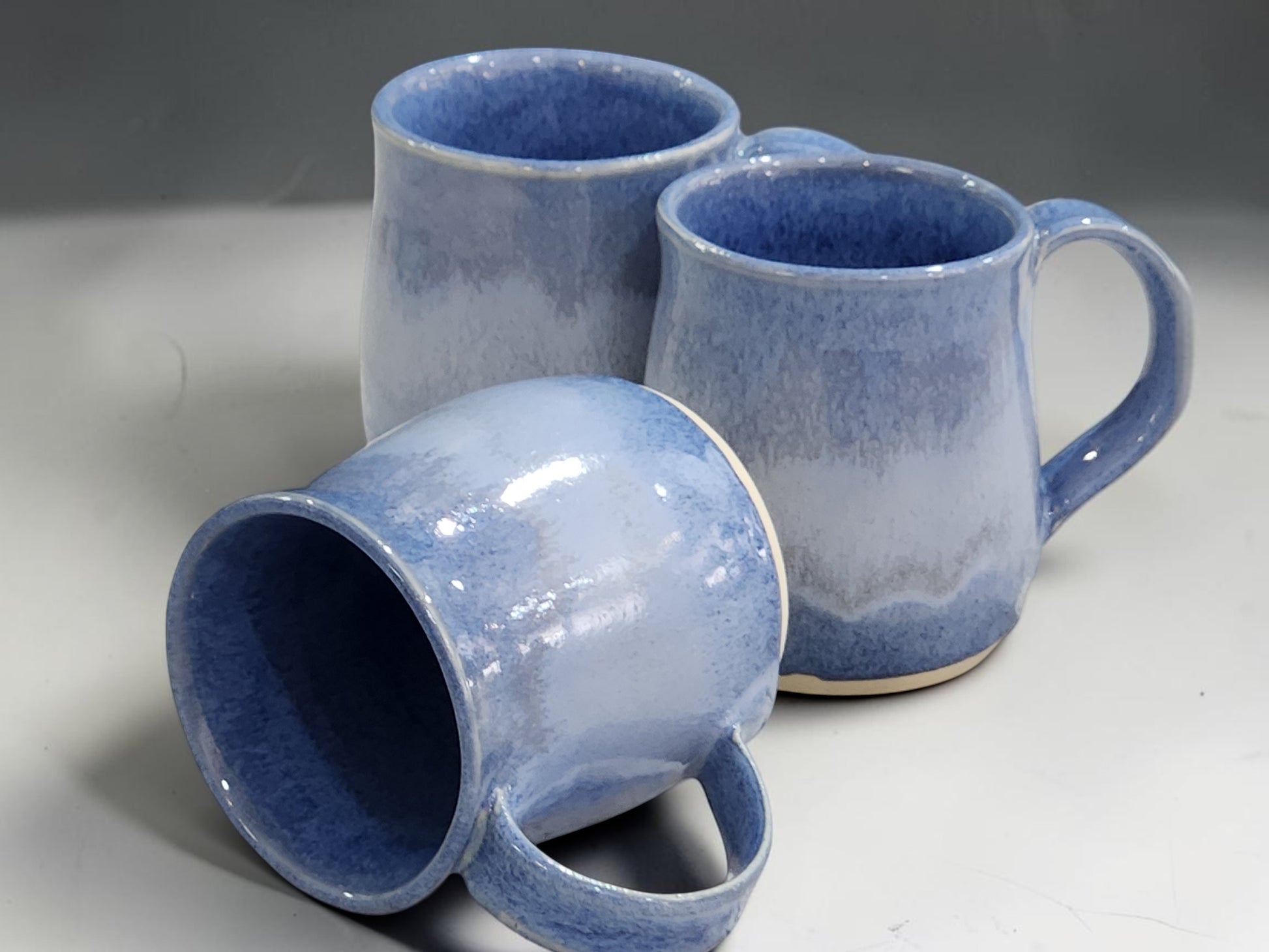 Artisan stoneware mugs with mottled blue glaze and comfortable handle