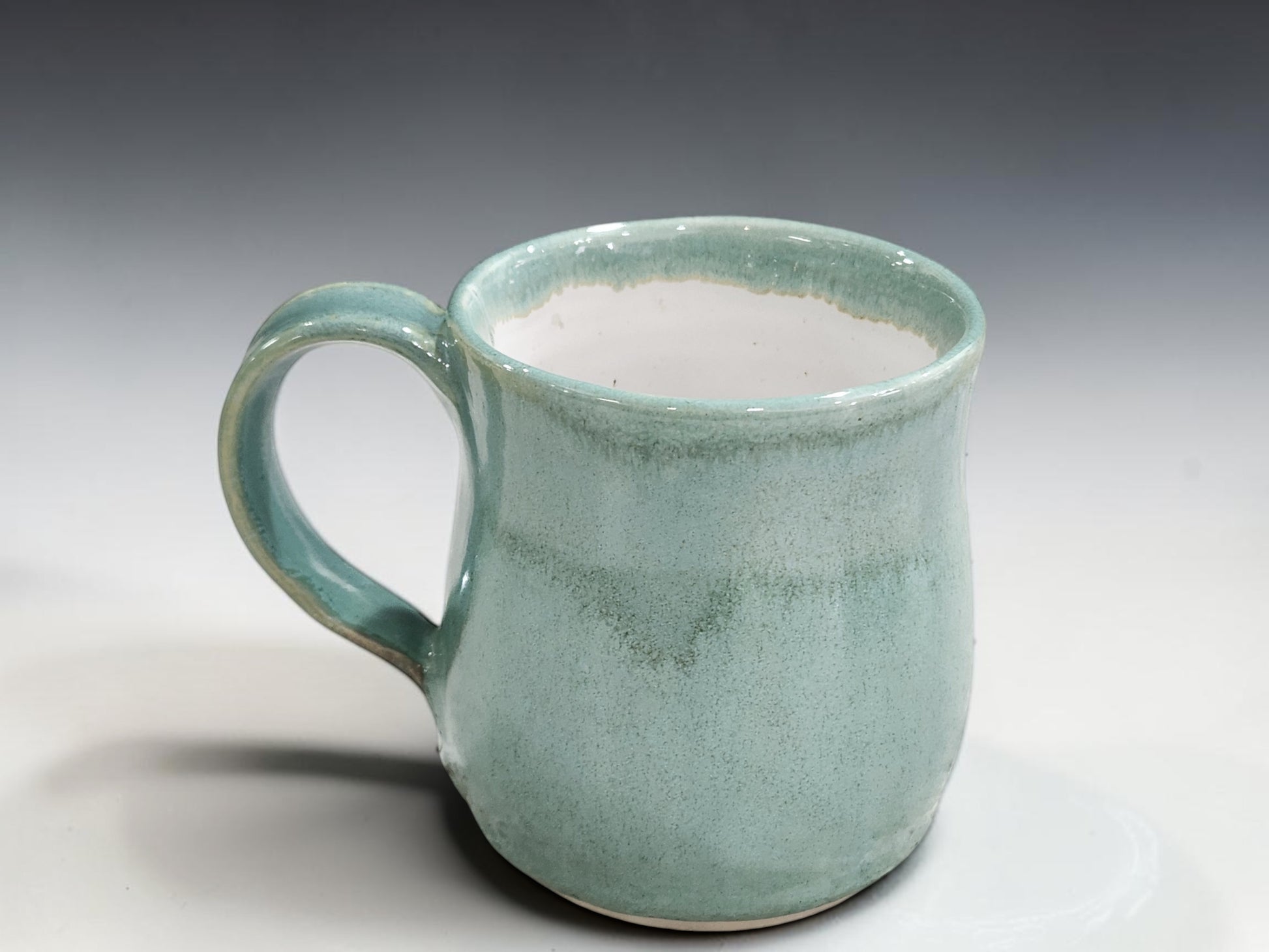 Artisan pottery mugs with comfortable handles in calming spearmint green glaze
