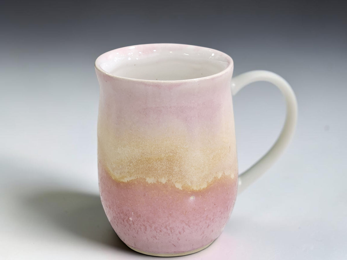 Side view of handmade 350ml pottery mug with curved pink handle