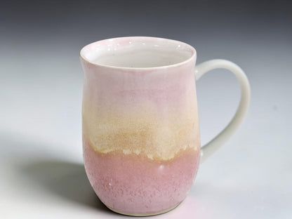 Side view of handmade 350ml pottery mug with curved pink handle
