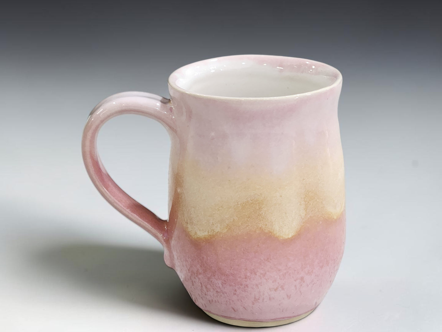 Glossy glazed interior of pink and oatmeal handmade stoneware mug