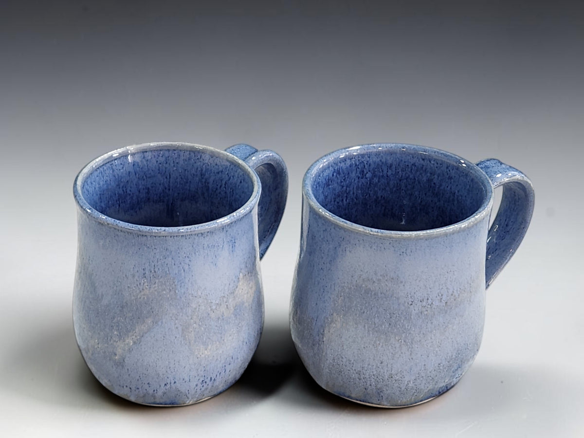Mottled blue ceramic coffee mugs with deep blue speckled interiors