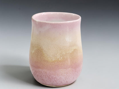 Large handmade pink coffee mug with flowing creamy oatmeal glaze