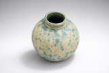 Handmade ceramic vase angled top view showing glossy green-blue interior glaze and teal crystals on cream matte surface