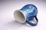 Angled view of blue crystalline glaze mug showing rounded form