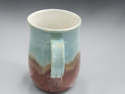 Handmade pottery mug with comfortable handle and tall shape