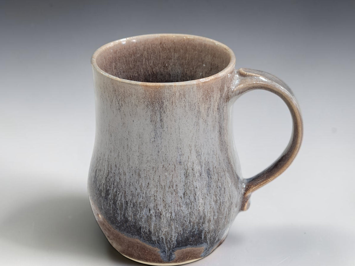 Brown handmade mug with softly layered blue-grey glaze detail