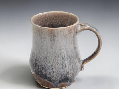 Brown handmade mug with softly layered blue-grey glaze detail