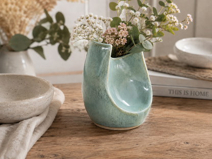Handmade seafoam ceramic altered vase with delicate flowers in a contemporary home setting by Buxton Pottery Australia.