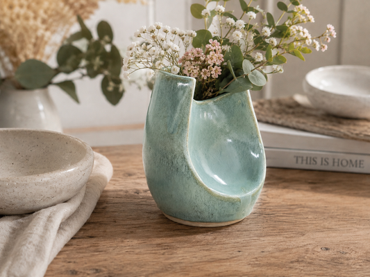 Handmade seafoam ceramic altered vase with delicate flowers in a contemporary home setting by Buxton Pottery Australia.