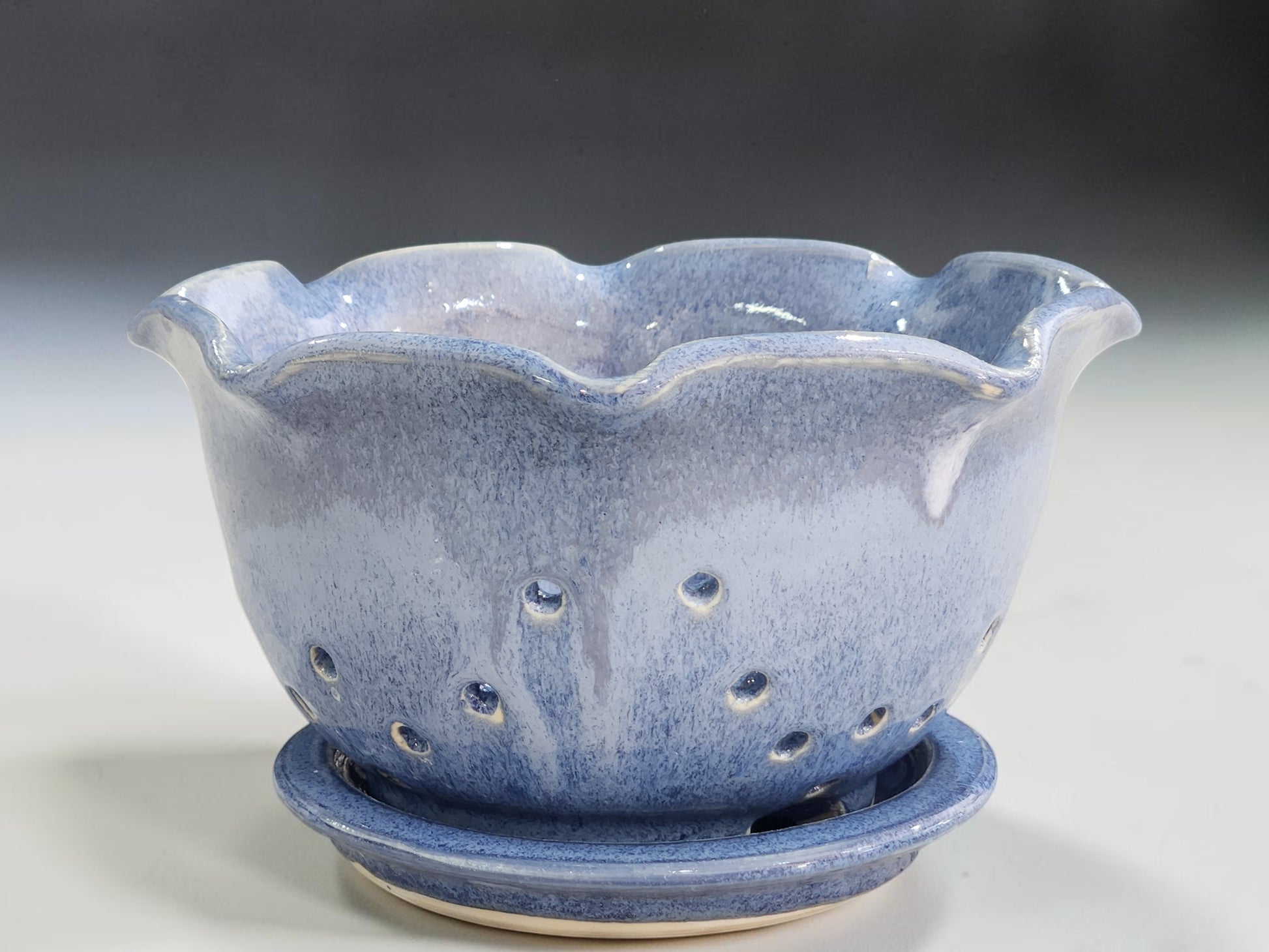 Handmade blue ceramic berry bowl with matching saucer