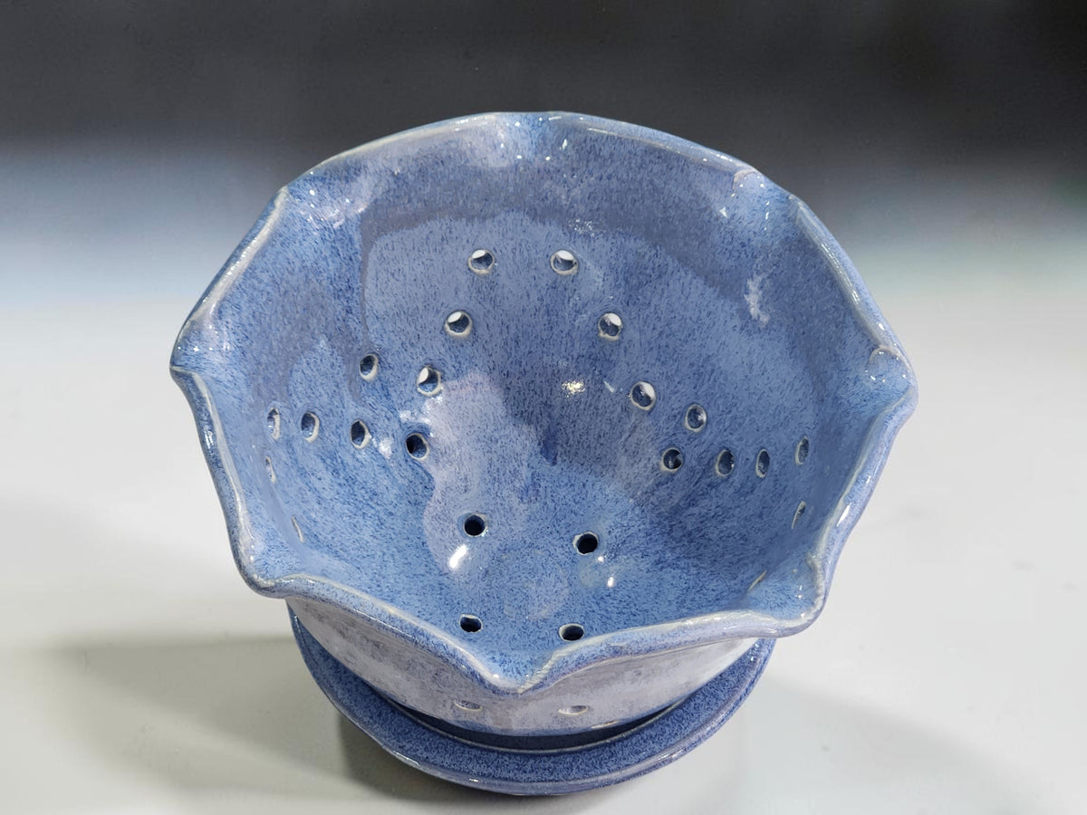Blue ceramic berry bowl in a bright kitchen lifestyle setting