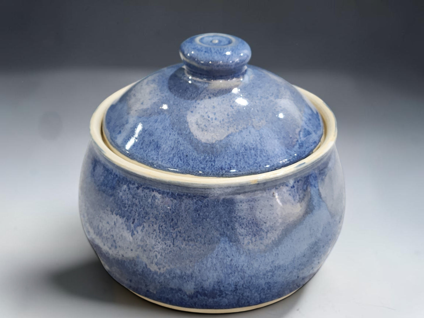 Handmade pottery lidded sugar bowl with rounded form and rich blue glaze variation