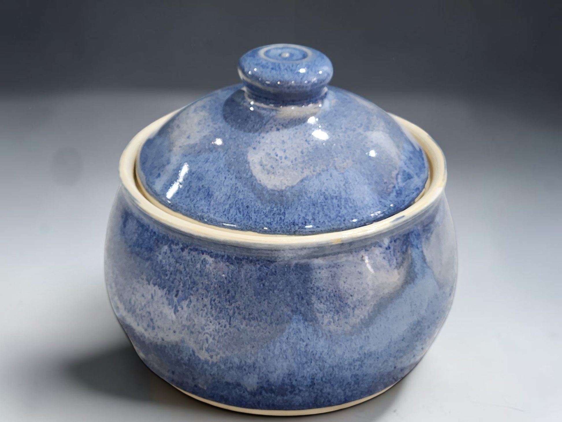 Handmade pottery lidded sugar bowl with rounded form and rich blue glaze variation
