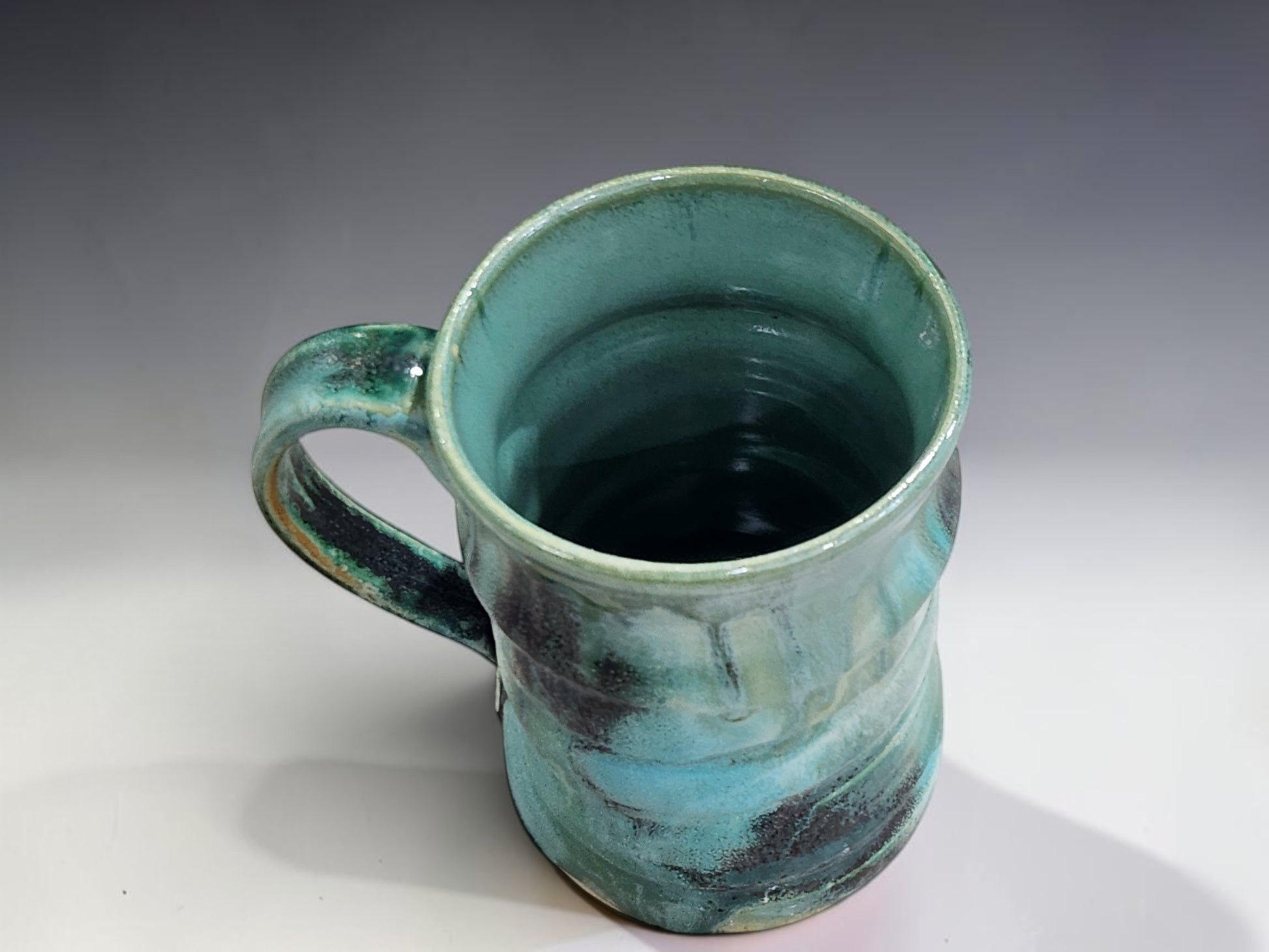 Handmade ceramic coffee mug in turquoise and deep green glaze, perfect for slow morning coffee