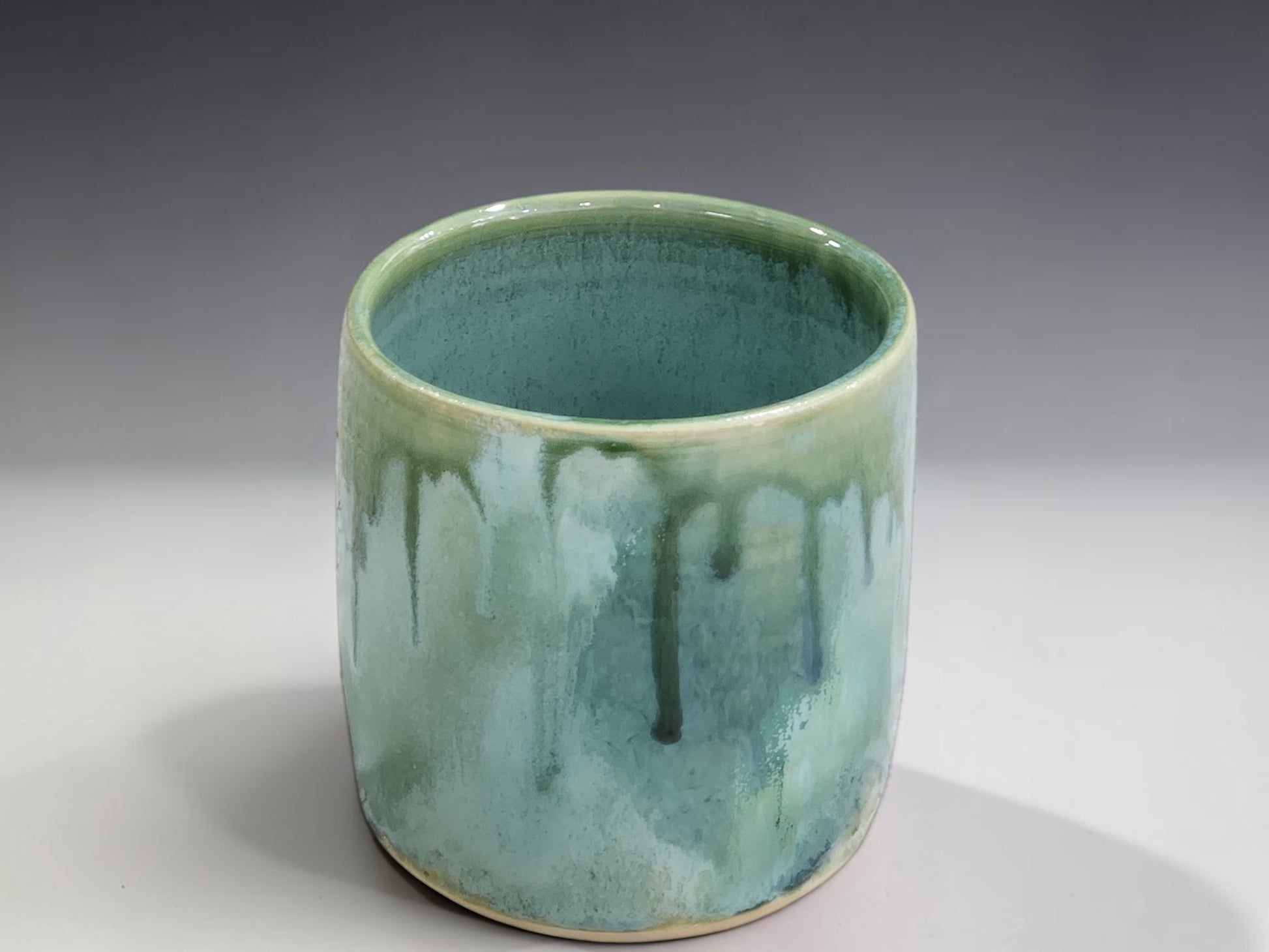One-of-a-kind handmade ceramic tumbler with layered green, aqua and earthy glaze tones