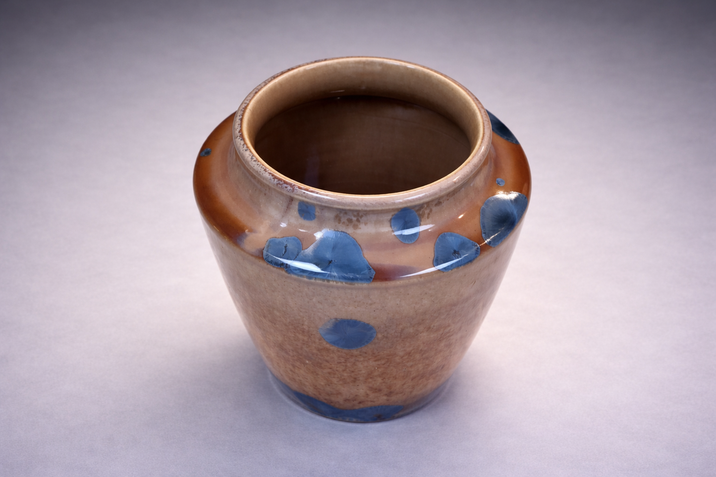 Handmade pottery vase with amber glaze and blue crystal accents by Buxton Pottery