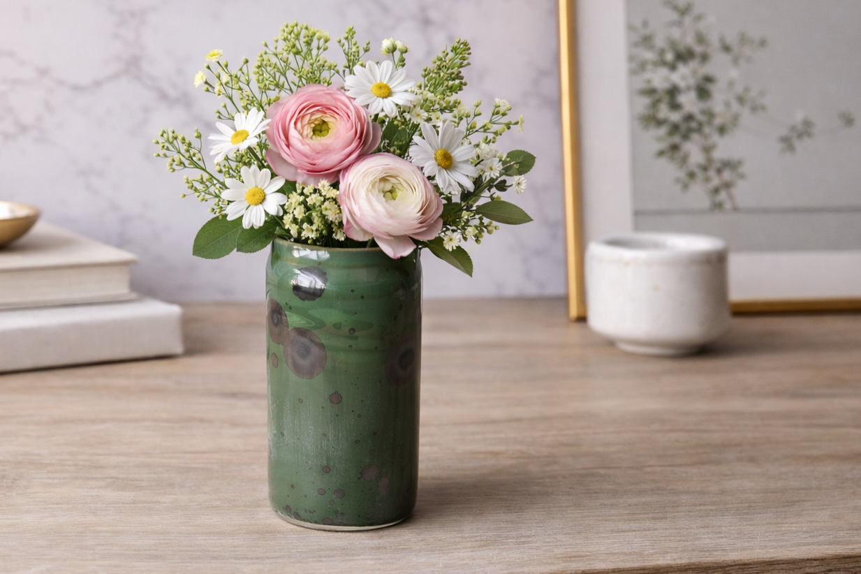 Green crystalline vase with dark crystals, with a small posy of flowers, made in our Melbourne studio.