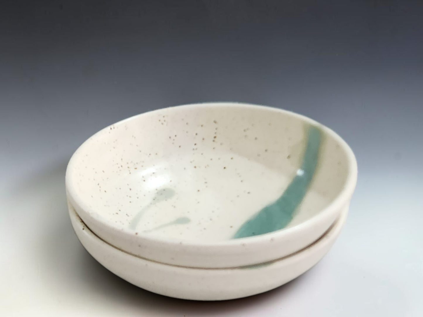 Handmade ceramic pasta bowl in speckled cream glaze with single green stripe, made by Buxton Pottery in Melbourne Australia