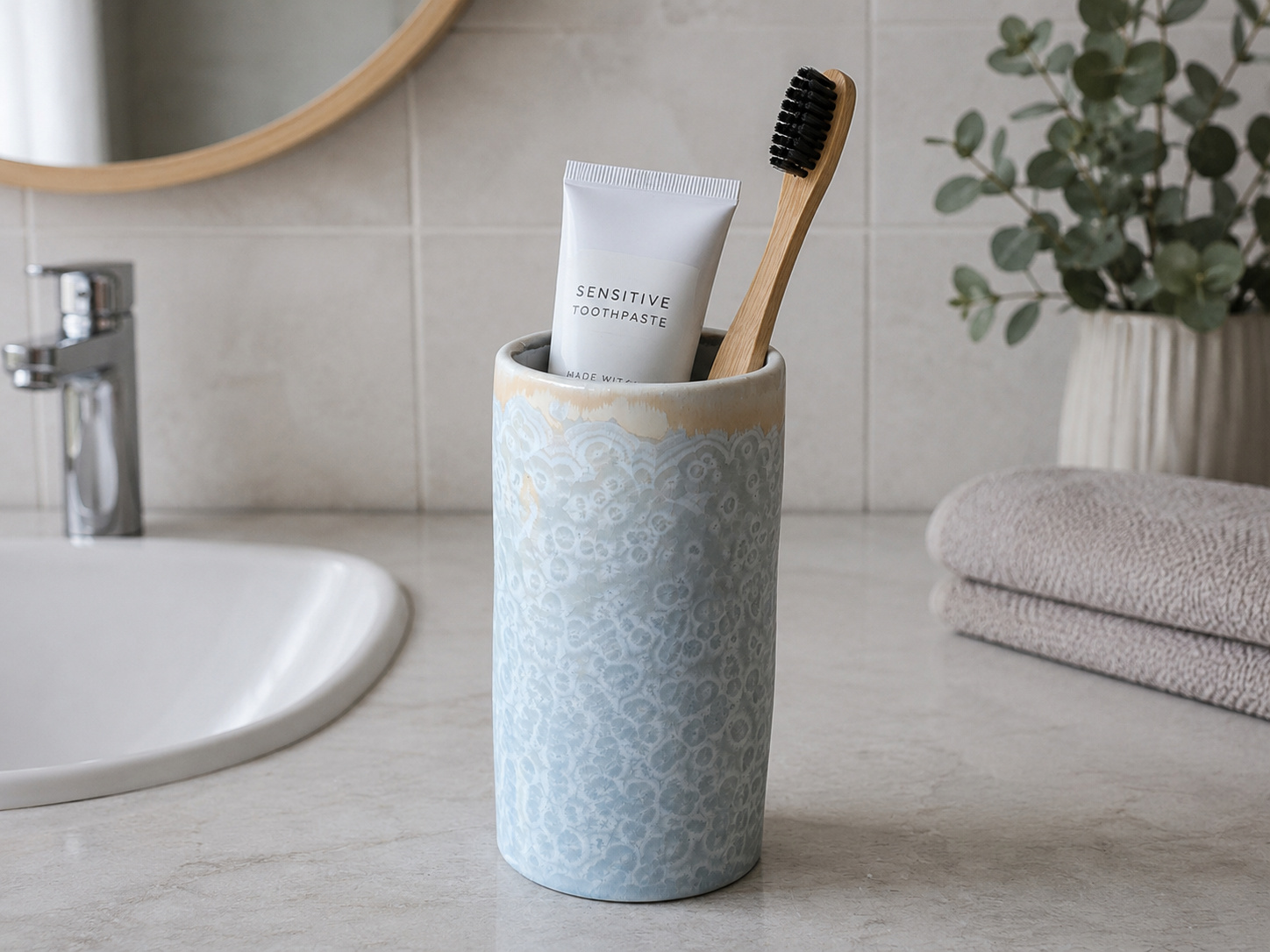Pale blue handmade pottery toothbrush holder with a crystalline glaze
