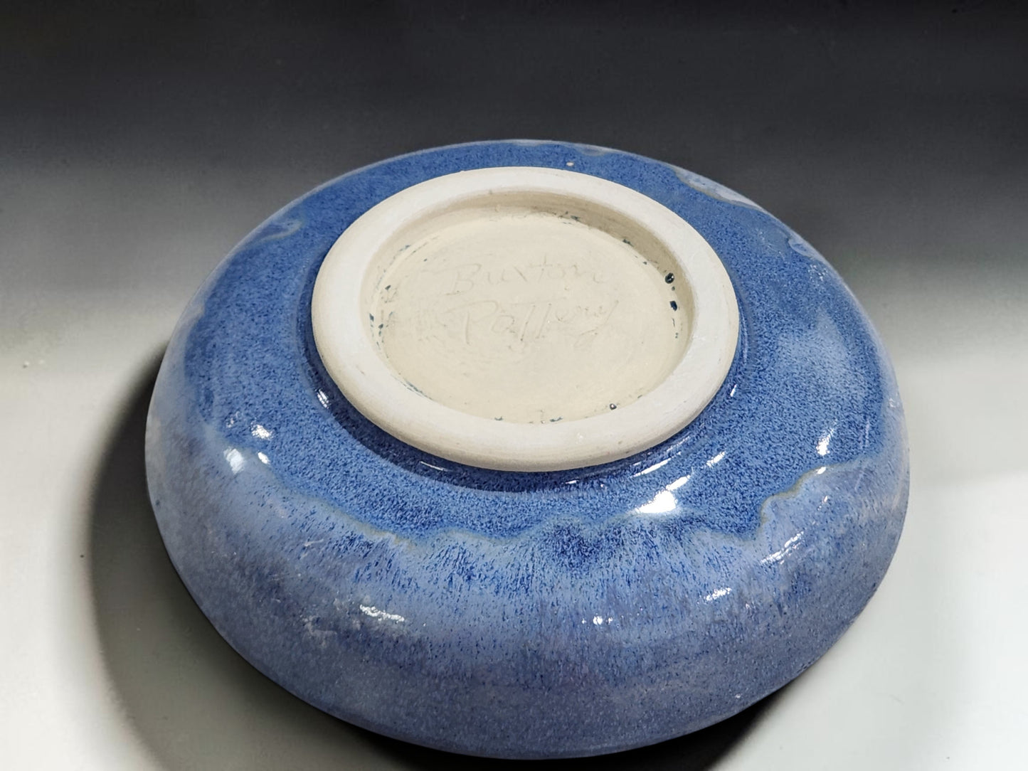 Handmade stoneware pasta bowl with flowing mottled blue glaze