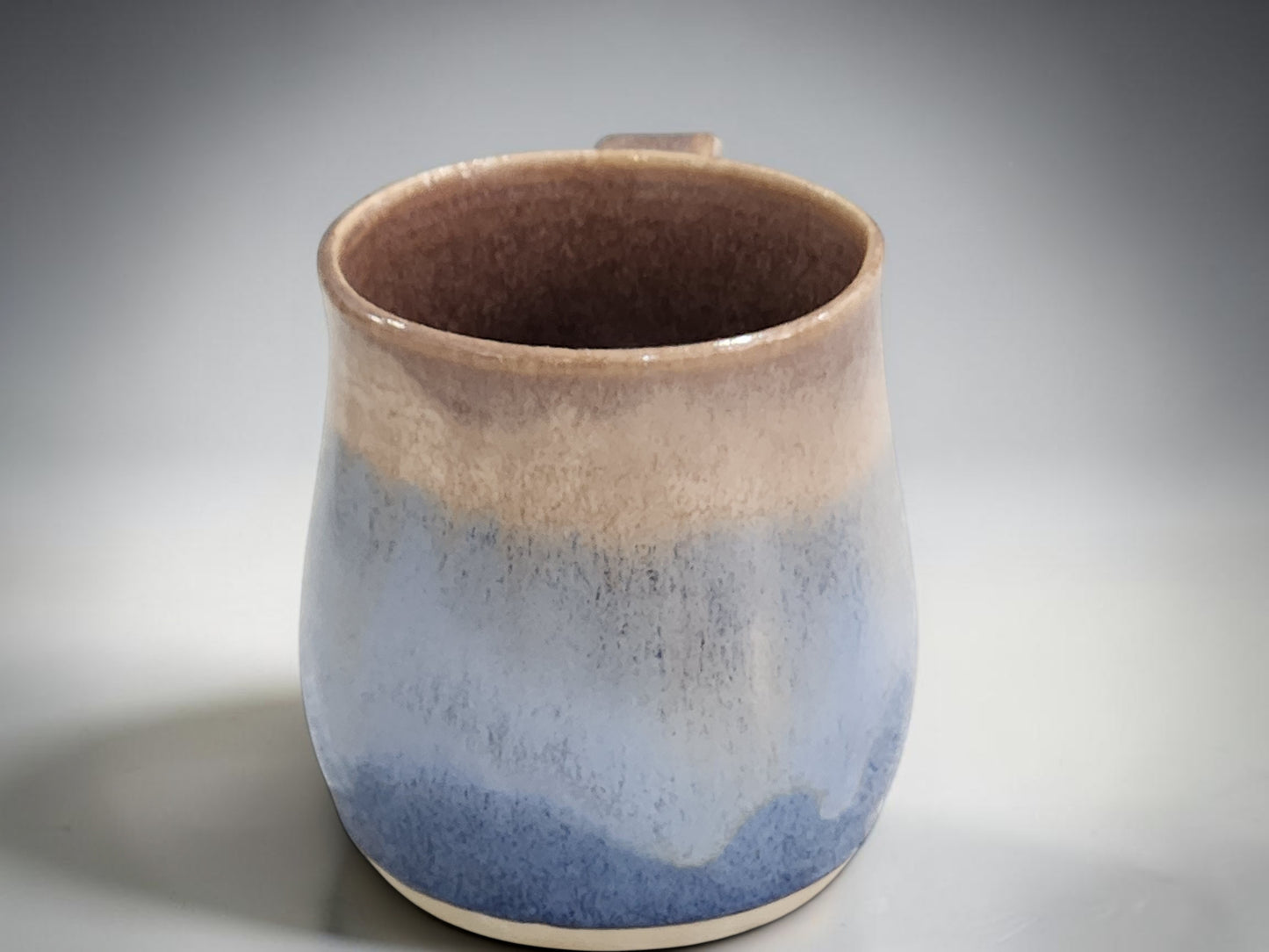 Blue and oatmeal ceramic coffee mug handcrafted pottery studio photograph