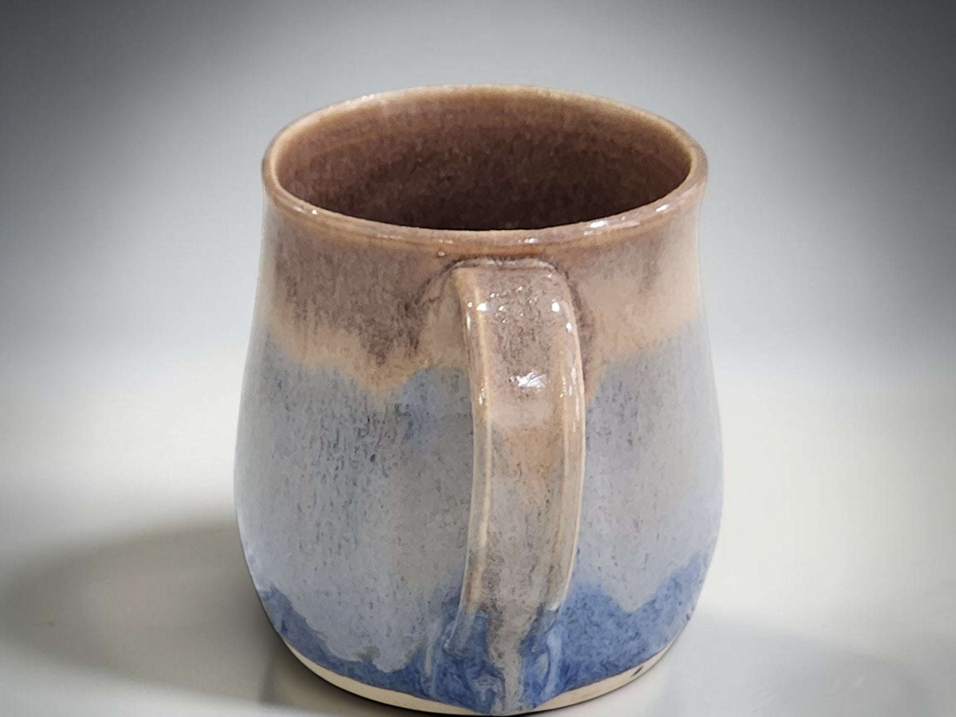 Australian handmade pottery mug in mottled blue and warm oatmeal tones