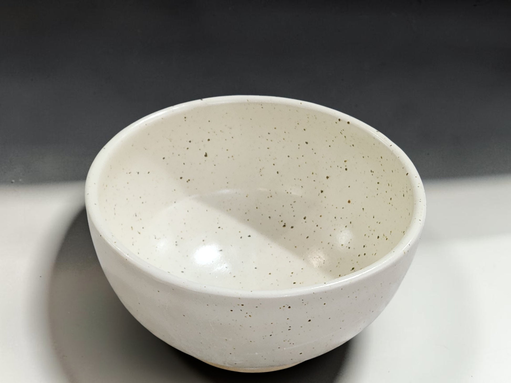 Contemporary handmade pottery bowl in speckled cream for everyday dining