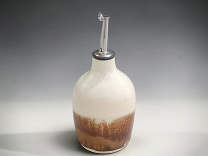 Handmade Australian pottery oil bottle beside olive oil dish