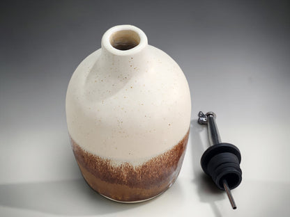 Rustic pottery oil dispenser with earthy brown glaze detail with spout out.