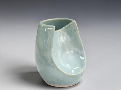 Side view of handmade ceramic altered vase in soft seafoam glaze