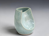 Side view of handmade ceramic altered vase in soft seafoam glaze