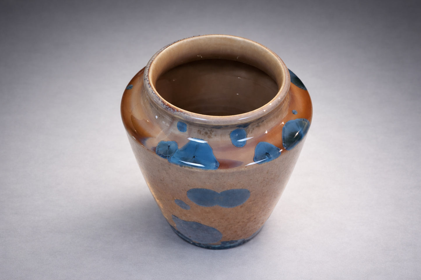 Amber and blue handmade ceramic vase photographed on a professional grey studio sweep