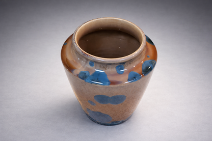 Amber and blue handmade ceramic vase photographed on a professional grey studio sweep