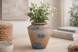 Handmade crystalline ceramic vase in amber glaze with blue crystals on a soft grey studio background