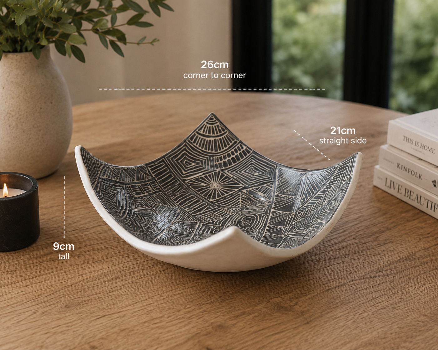 Hero image of black and white carved drape bowl displayed on rustic timber table with modern home décor accents