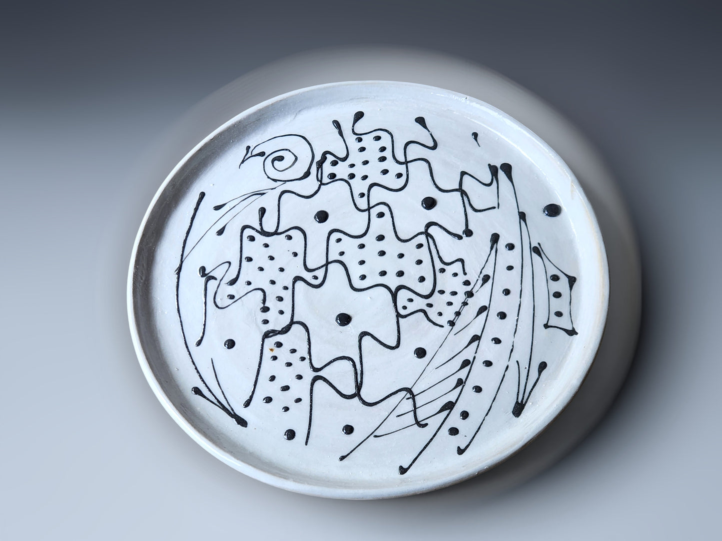 white stoneware plate with black design 