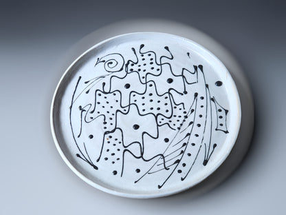 white stoneware plate with black design 
