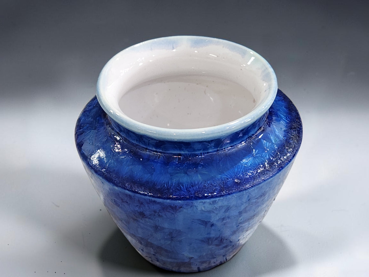 Blue crystalline vase with glossy white interior glaze