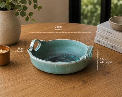 image of handcrafted turquoise ceramic bowl styled on timber table with modern home décor accents