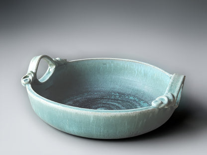Handmade turquoise ceramic bowl with sculptural loop handles and artisan glaze finish